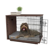 Ein hund, der in einer Omlet Fido Studio hundebox aus nussbaumholz sitzt.