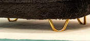 Eine Nahaufnahme der goldfarbenen Haarnadelfüße für das Donut-Katzenbett