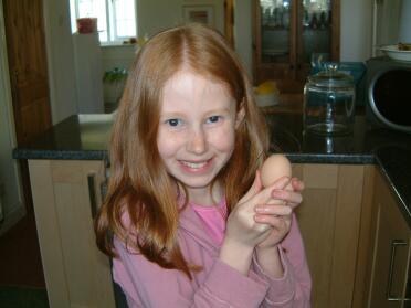 Emily hält stolz unser erstes Ei. Wir denken, es kam von Dorothy.