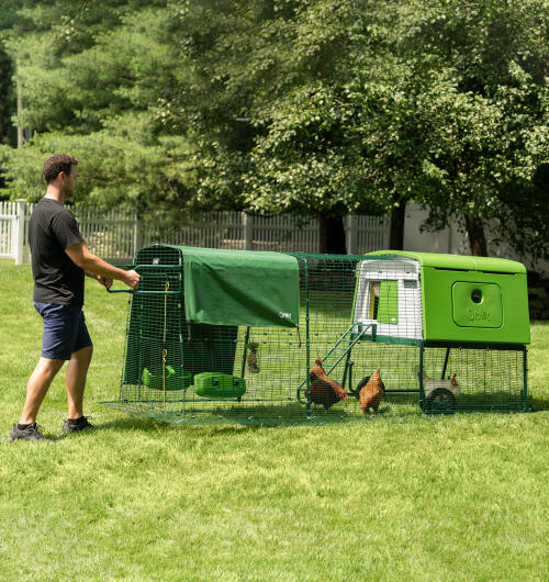 Ein mann, der seinen Eglu Cube hühnerstall umzieht