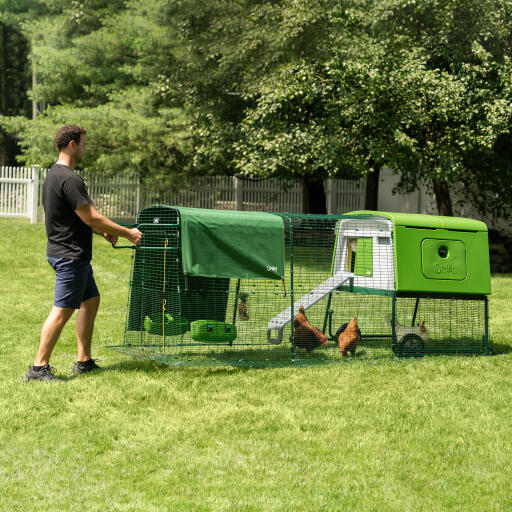 Mann bewegt den Eglu Cube tragbaren hühnerstall aus kunststoff