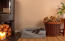 Ein kleiner schwarzer hund, der in einem wohnzimmer auf einem grauen memory-foam-rollenbett liegt