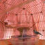 Ein modellvogel, der auf einem futterhäuschen in einem rosa vogelkäfig mit spiegel sitzt