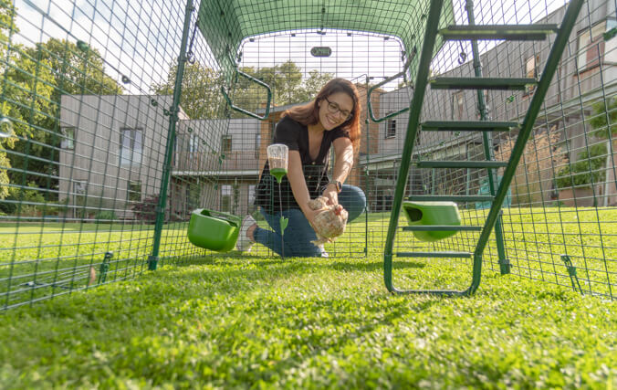 Eine Frau, die sich in den Auslauf des Eglu Cube lehnt