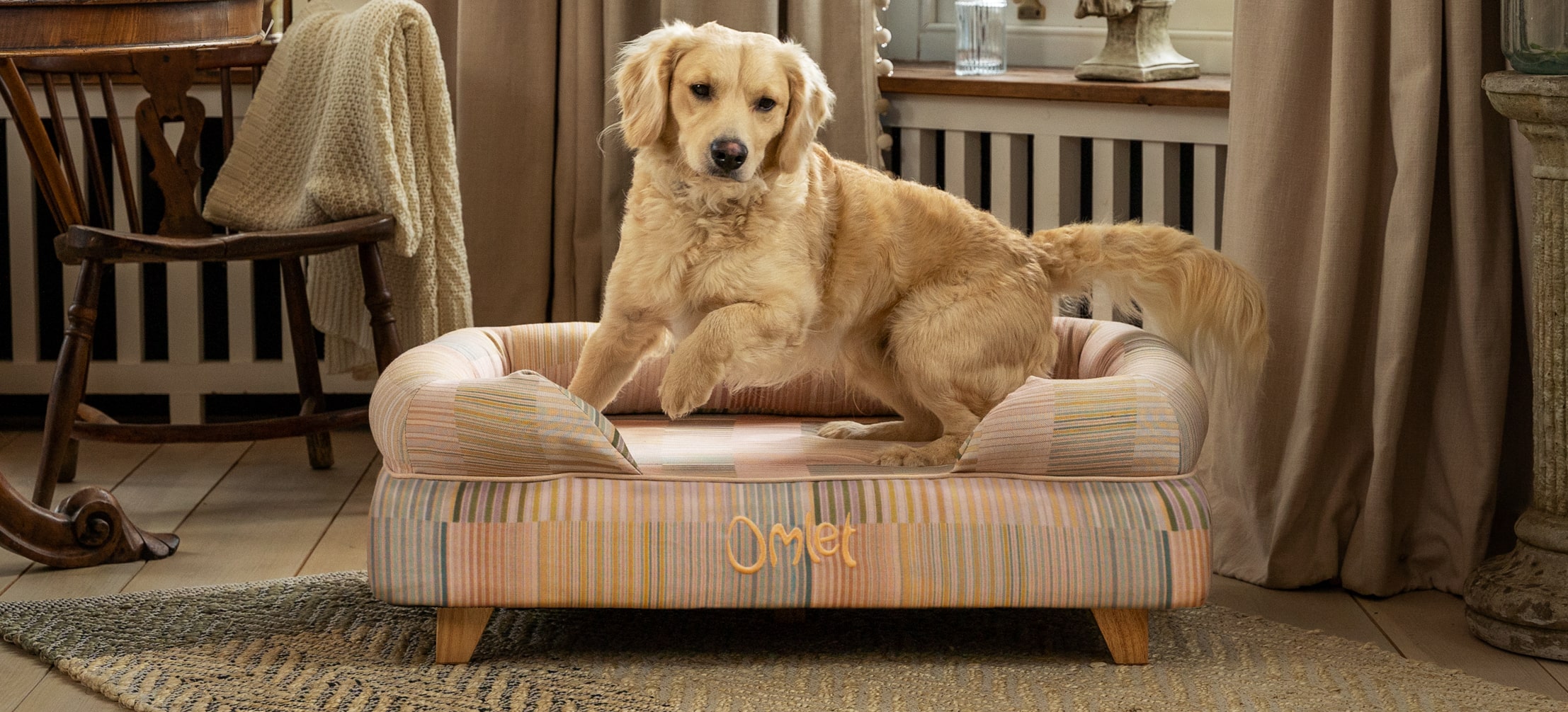 Ein Golden Retriever auf seinem Omlet Hundesofa mit dem Motiv Pawsteps Natural